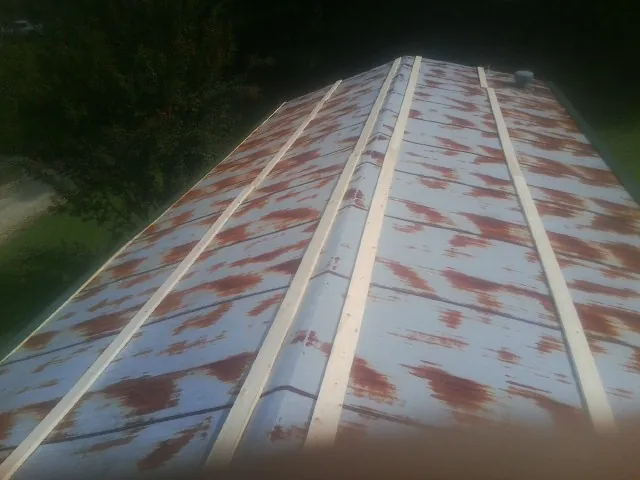 Rusted metal roof panels with new wood purlins before replacement — Storm Damage Roof Repair in West Mansfield by Roofing Brothers
