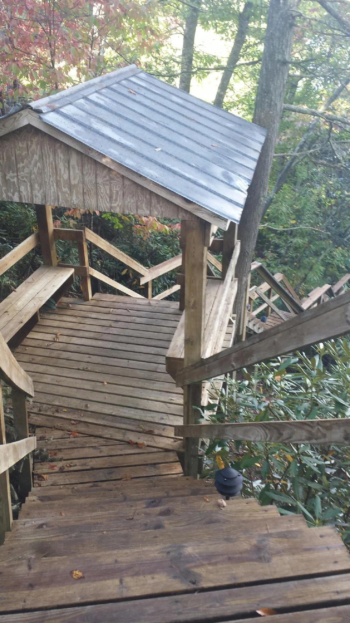 Metal roofed shelter over wooden steps on a wooded walkway — Skylight Repair & Installation work by our crew in West Mansfield