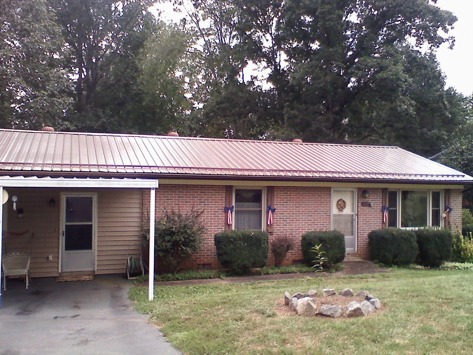 Bronze metal roof and carport on a brick ranch home — Roof Repair work by our crew in West Mansfield